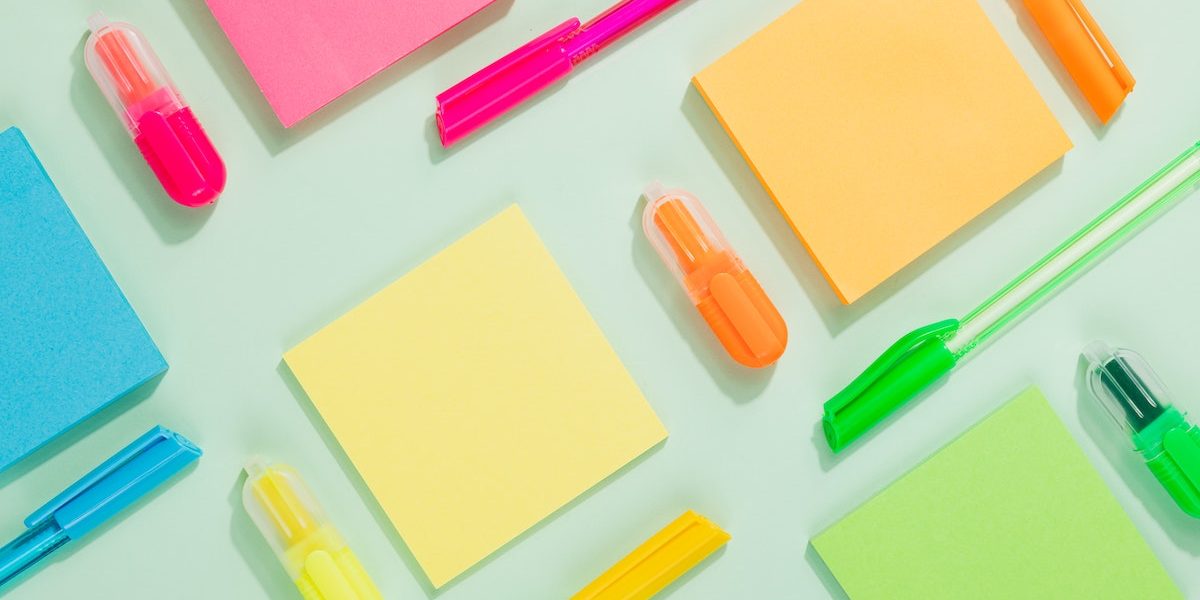 sticky note pads and markers arranged in a geometric pattern